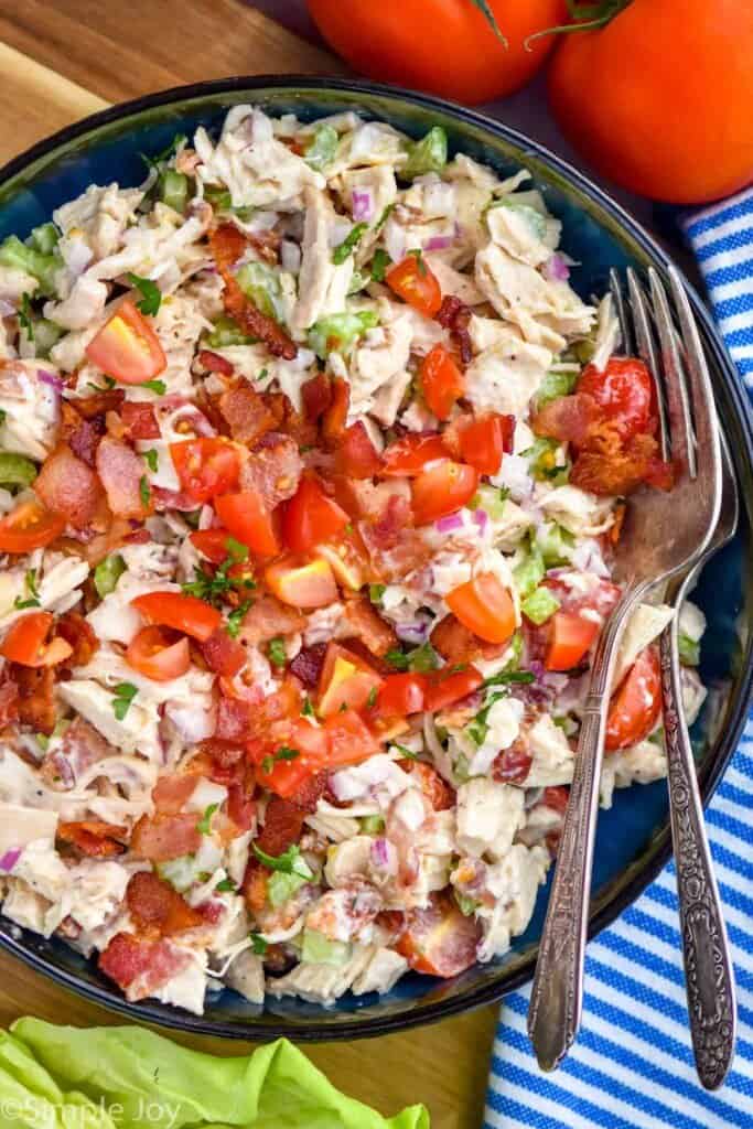 overhead of a bowl of chicken salad made with bacon and tomatoes