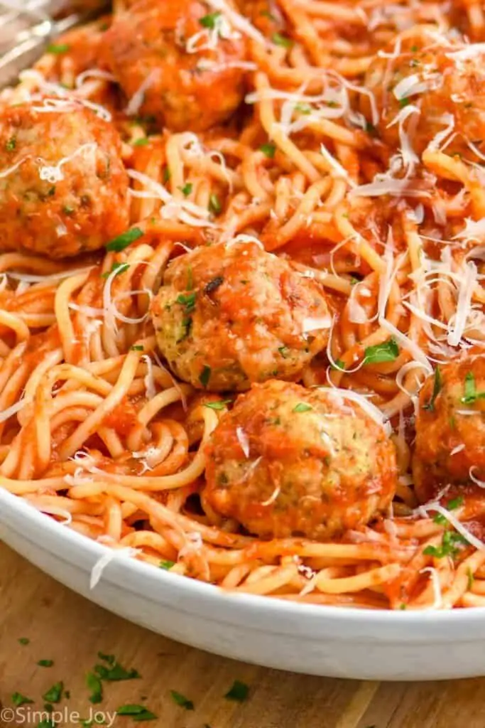 close up of a chicken meatball in a bowl with spaghetti