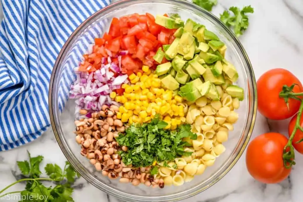overhead of a bowl of ingredients for cowboy caviar pasta salad