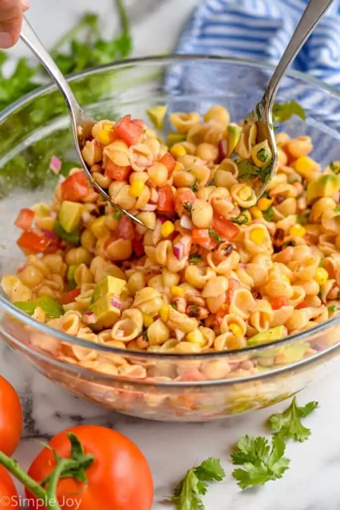 spoon and fork mixing up a big bowl of pasta salad