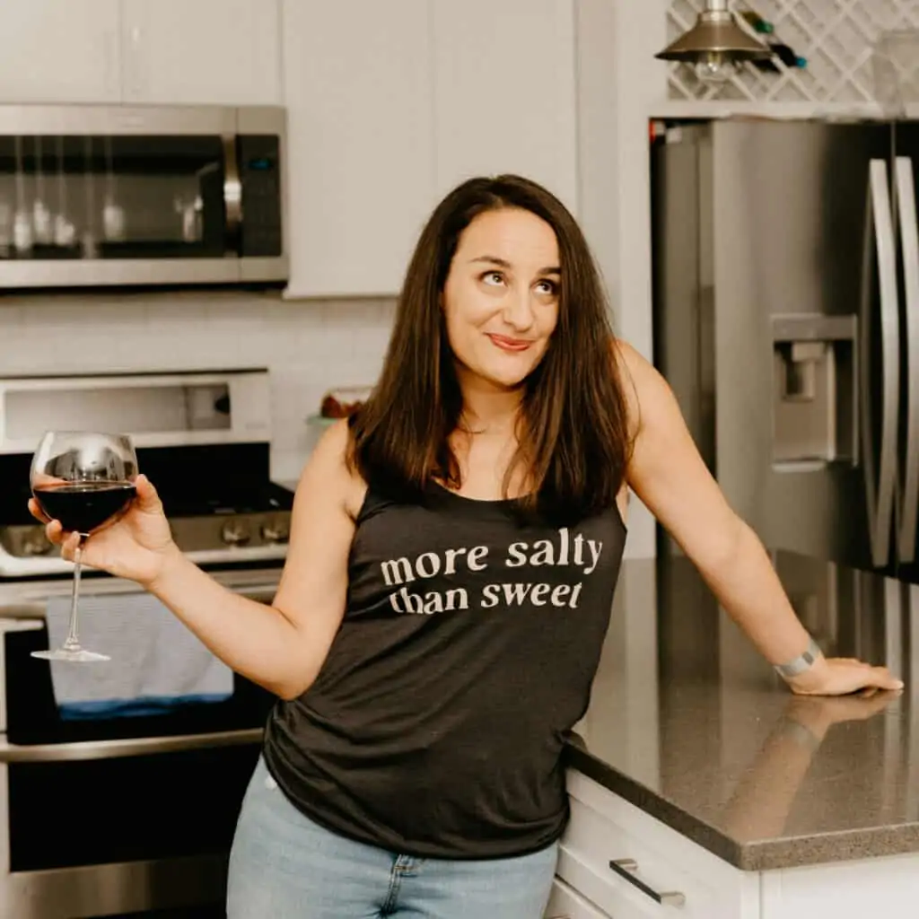 woman in a black tank top that says "more salty than sweet"