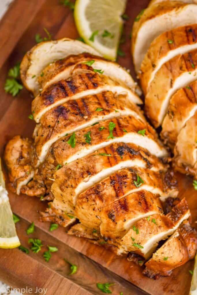 grilled chicken that has been marinated cut up on a cutting board