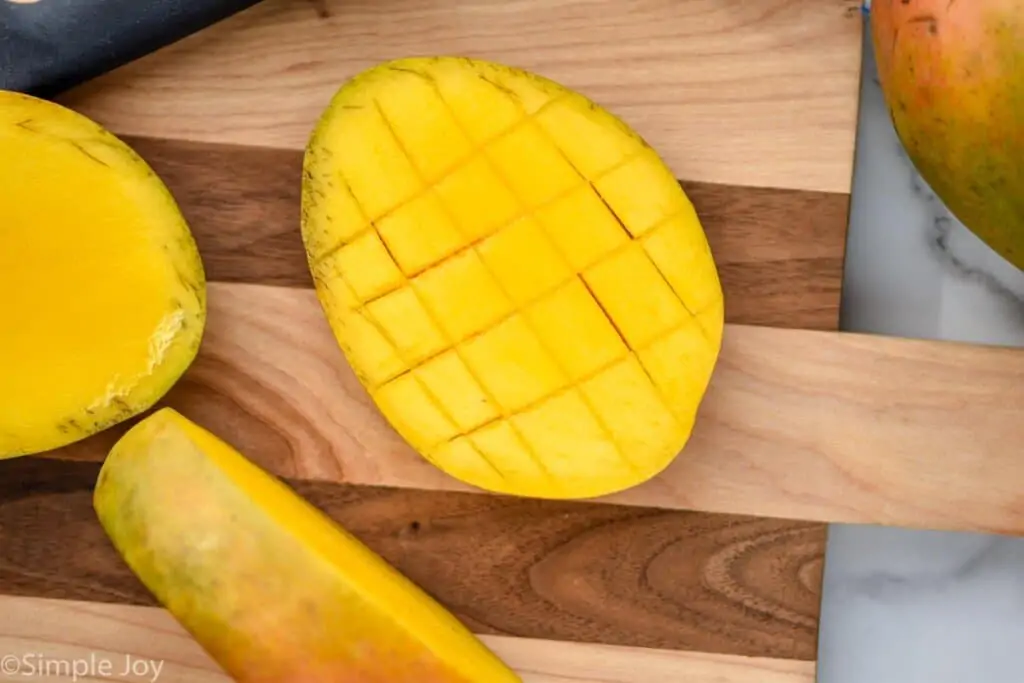 half of a mango that has been scored for easy cutting