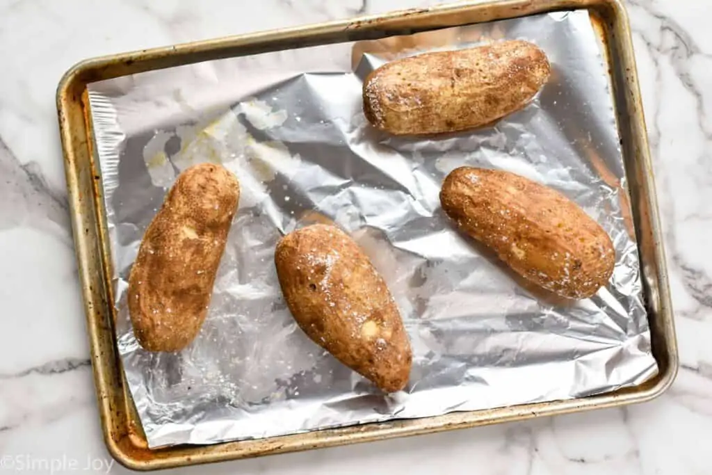 russet potatoes that have been oiled and salted on a baking sheet