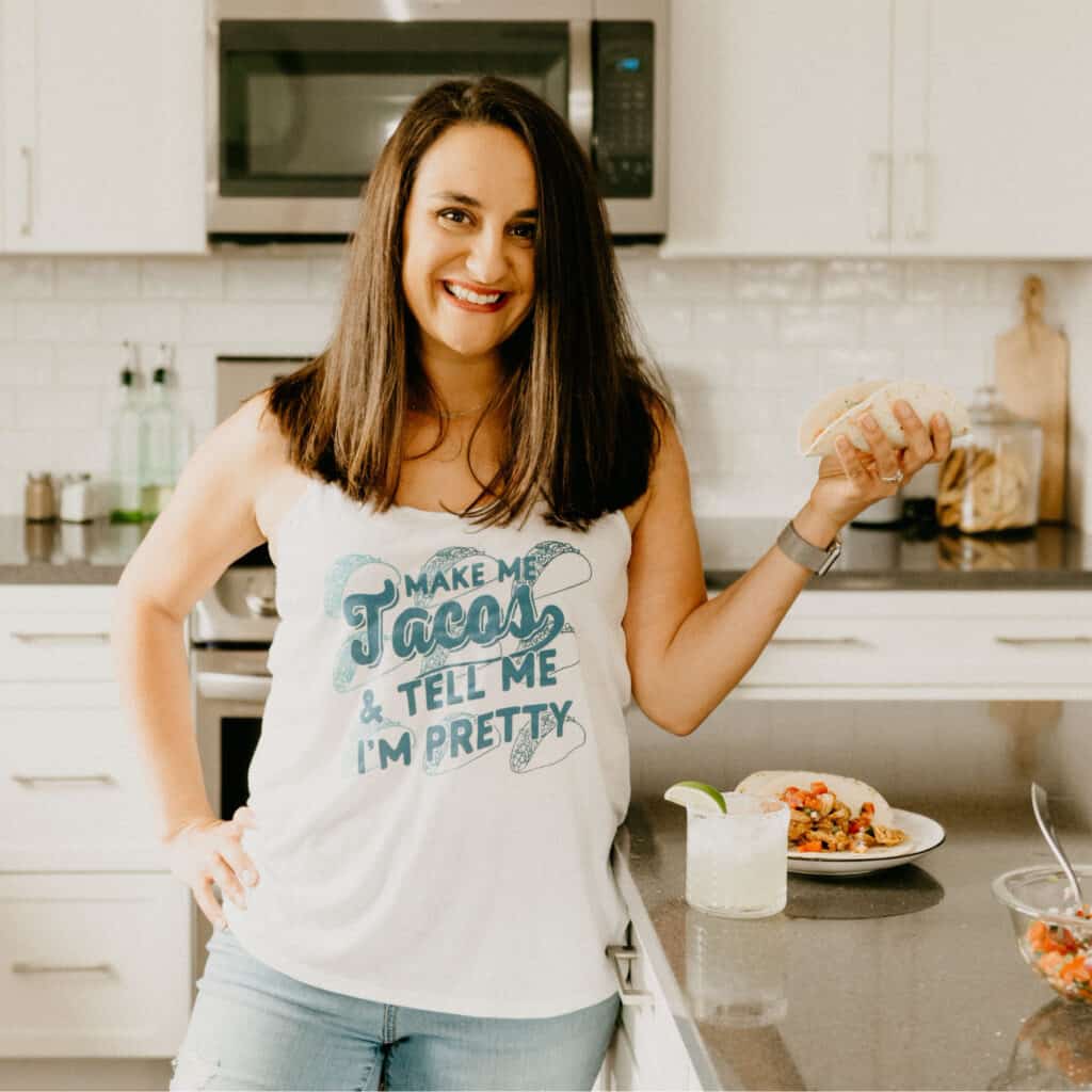 woman in a white tank top that says "make me tacos and tell me I'm pretty"