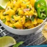 pinterest graphic of a small white bowl full of mango salsa