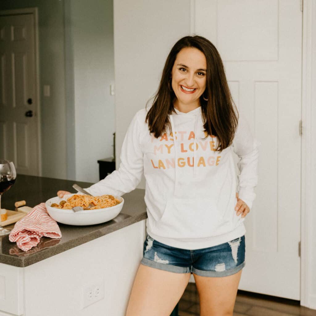 woman in a white hoodie that says "pasta is my love language"