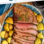 pinterest graphic of overhead of a London broil recipe cut up on a platter with baby potatoes around it
