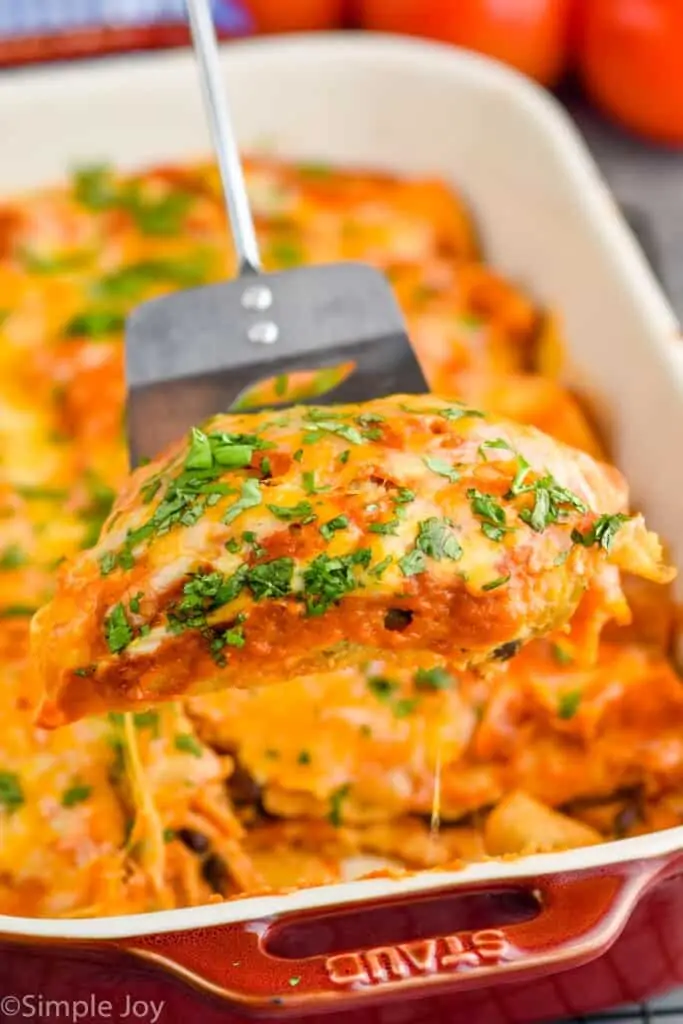 close up of black bean enchilada recipe being dished up out of a baking dish