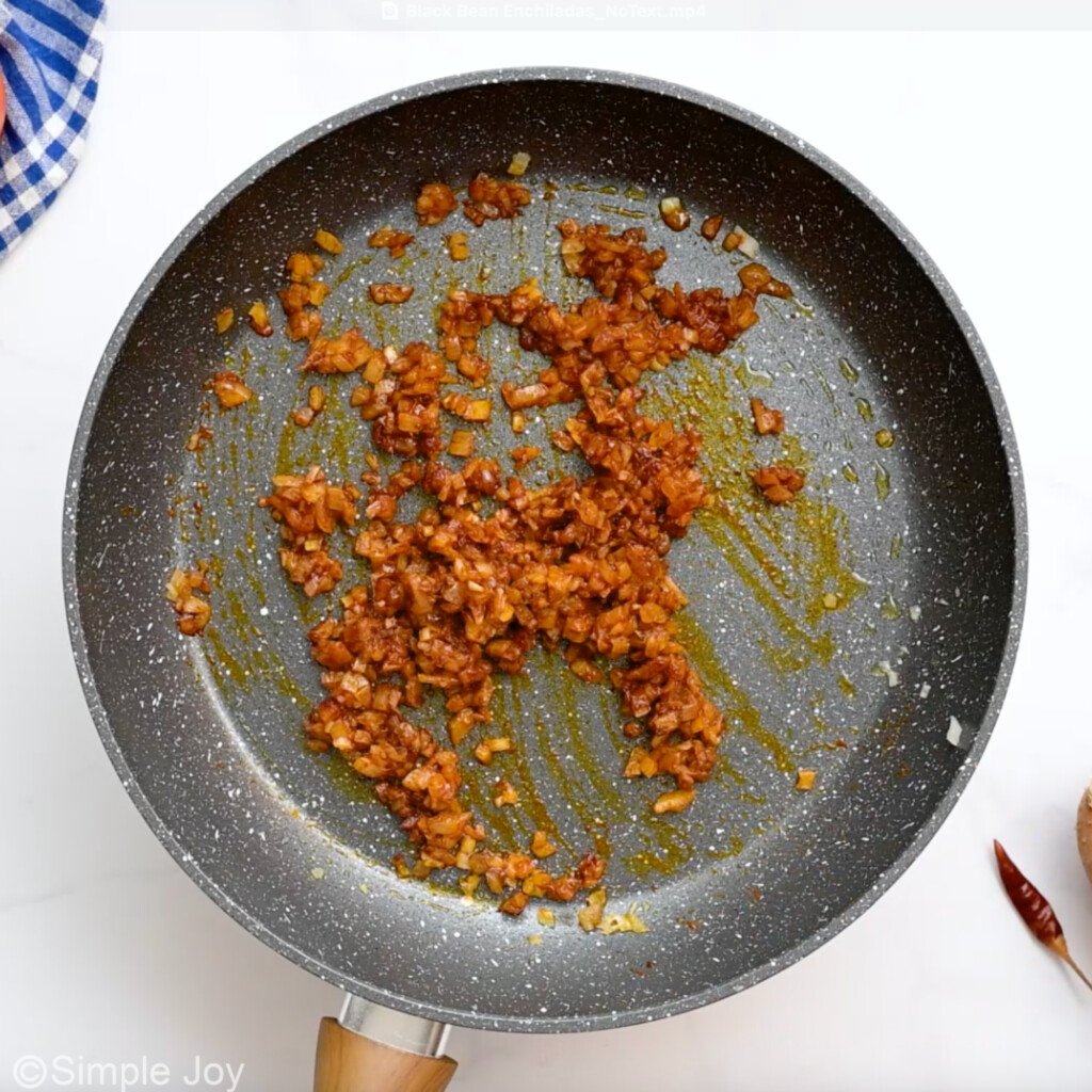 overhead of skillet of onion and seasonings to make black bean enchiladas  - 5