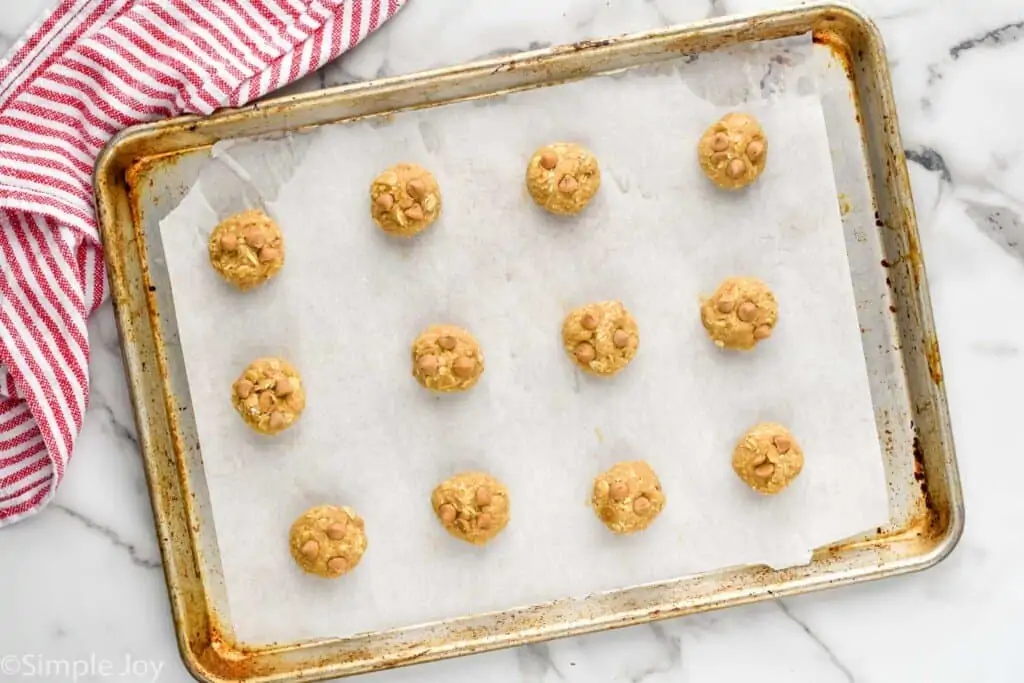 overhead of balls of oatmeal scotchies recipe dough on a baking sheet