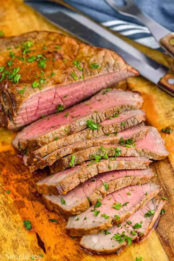 a London broil cut up on a cutting board