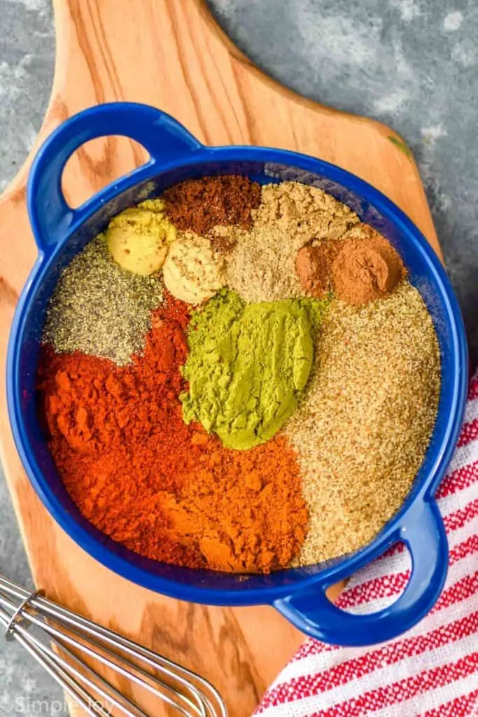 overhead of a small blue dish with old bay seasoning ingredients separated by spice