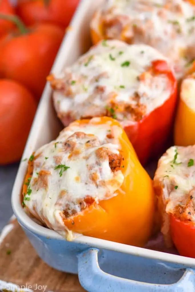 close up of an orange stuffed bell pepper in a baking dish