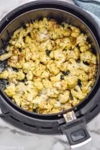 overhead of air fryer cauliflower in the air fryer basket