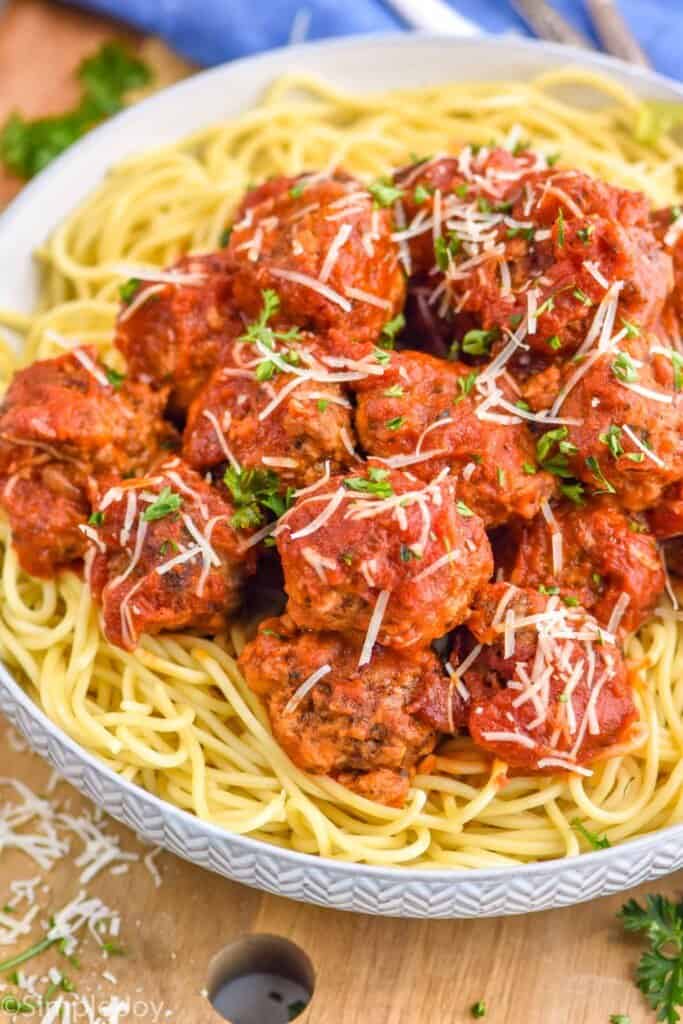 a crockpot meatball recipe on top of spaghetti