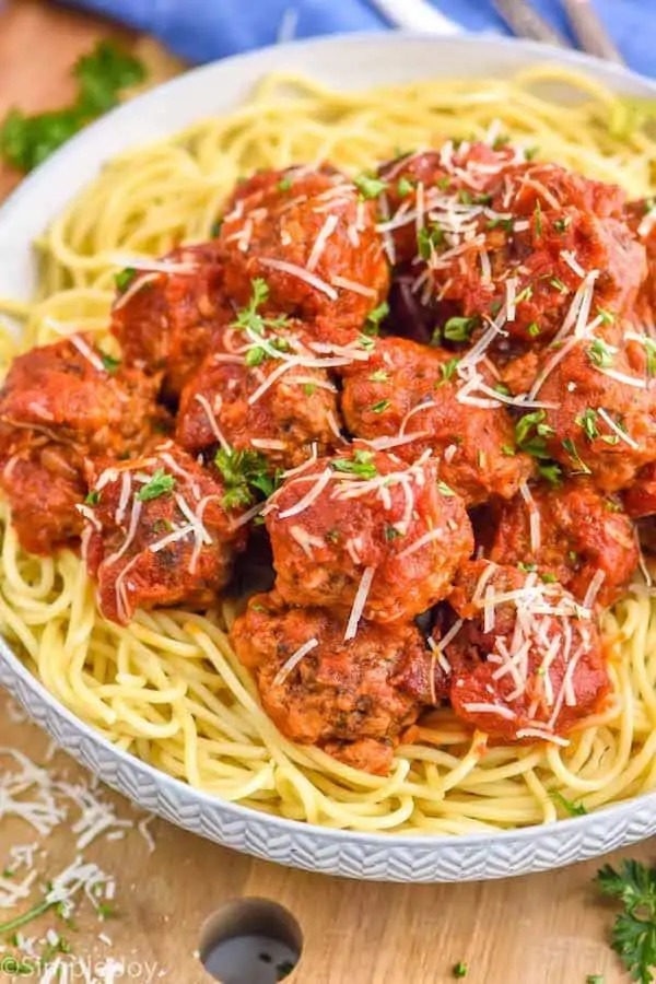 a crockpot meatball recipe on top of spaghetti