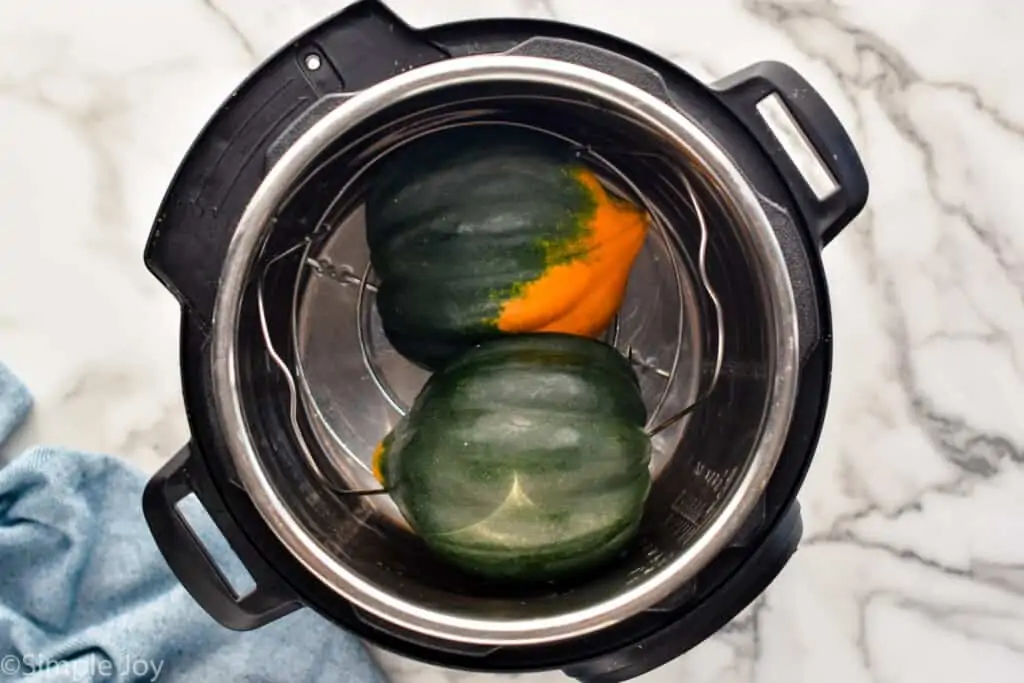 overhead picture of an acorn squash that has been cut in half inside of a pressure cooker