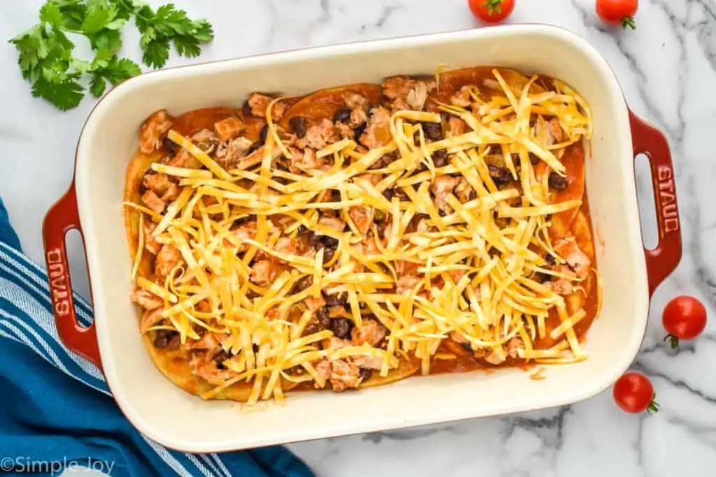 overhead of a baking dish showing layer of casserole with cheese on top and chicken and beans beneath