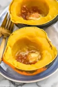 a cooked acorn squash with butter and brown sugar in it