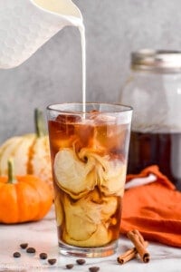cream being poured into pumpkin cold brew