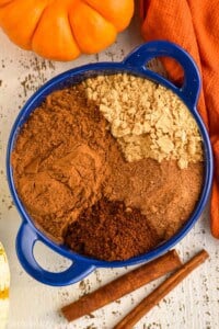 overhead of a small blue dish with the four different spices that make up pumpkin pie spice