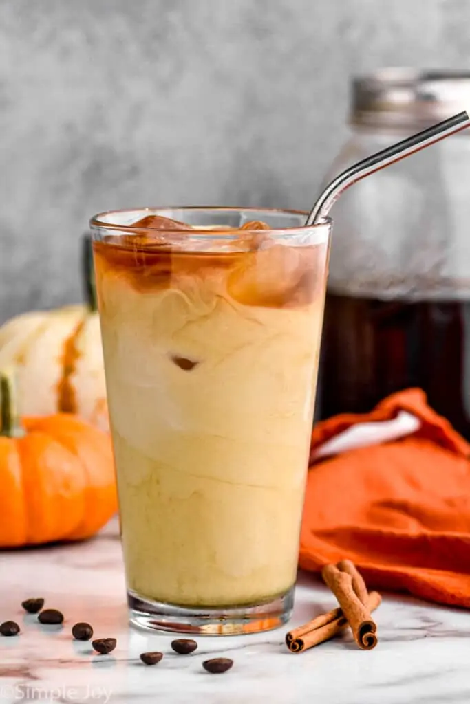 a tumbler full of pumpkin spice cold brew that has been mixed with cream