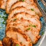 close up of turkey tenderloin recipe sliced and on a platter, garnished with parsley