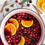 Pinterest graphic of overhead of a stock pot full of the best mulled wine and garnished with fresh cranberries and orange slices