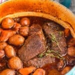 pinterest graphic of side view of a pot roast in a dutch oven with vegetables that was cooked in the oven