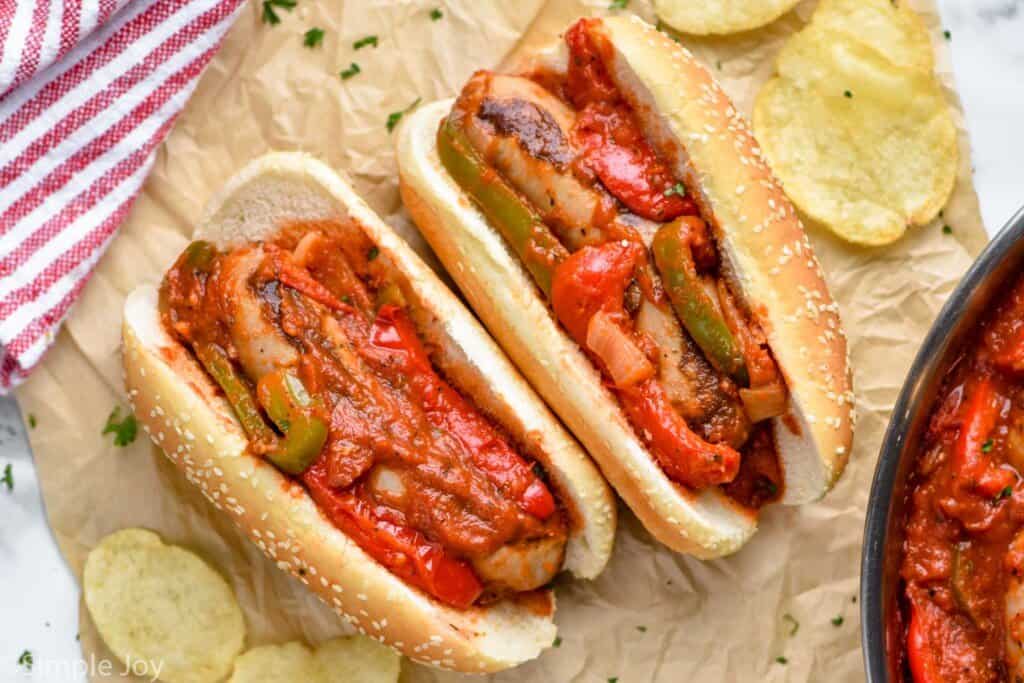 overhead of sausage, peppers, and onions in two buns