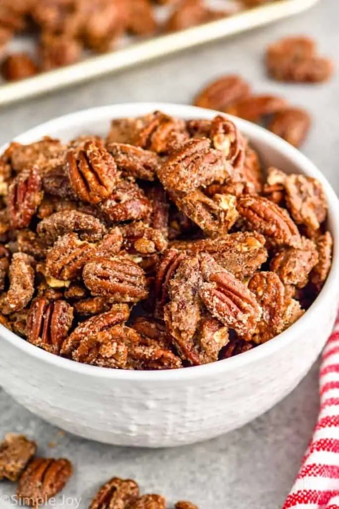 small white bowl full of candied pecans