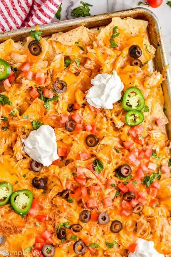 close up overhead view of chicken nachos on a sheet pan