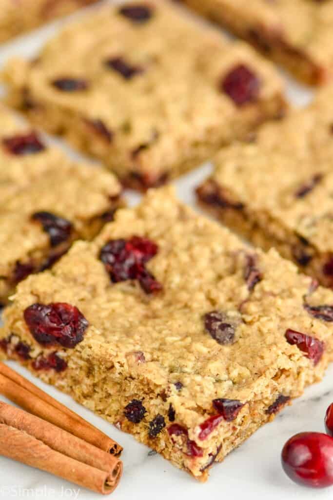 four oatmeal cranberry bars sitting on a white background