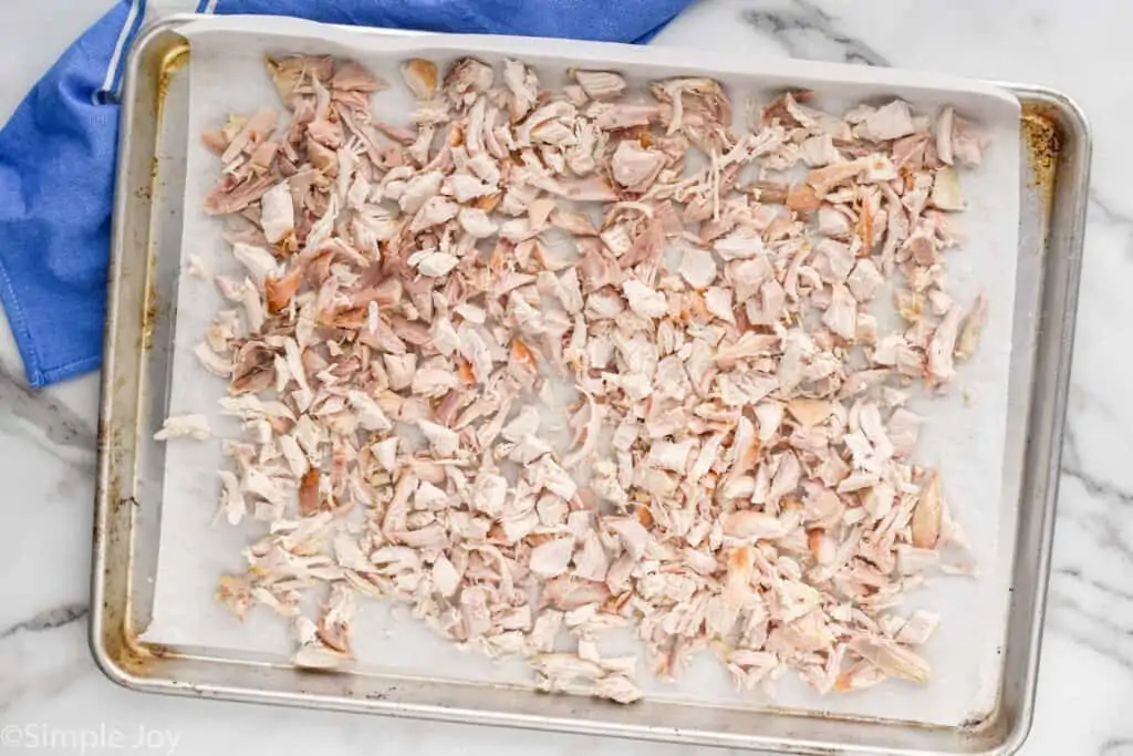 overhead of a rimmed baking dish with cut up rotisserie chicken