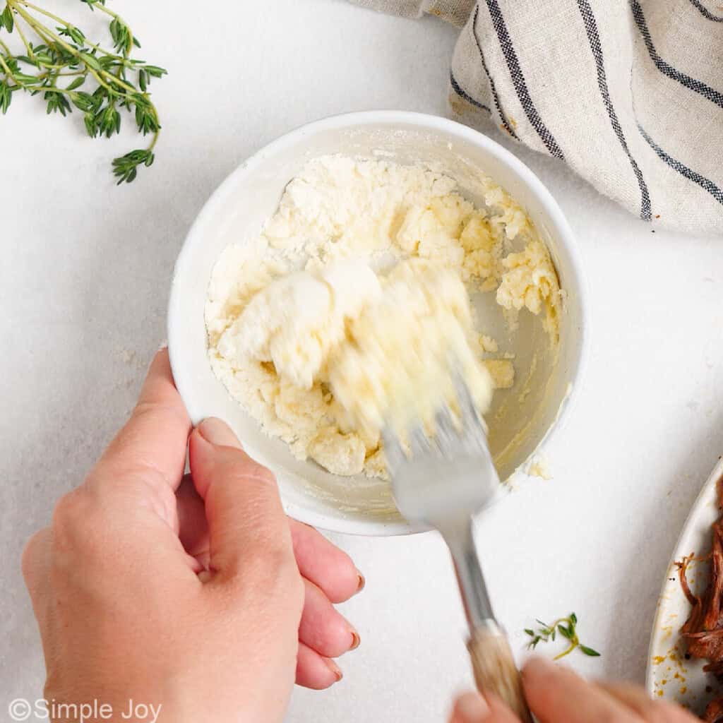 a fork combining butter and flour in a bowl