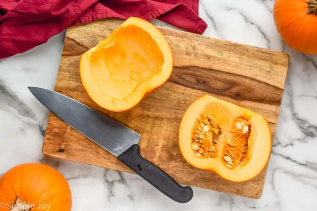 overhead of a pumpkin cut in half with the pulp removed from one of the halves