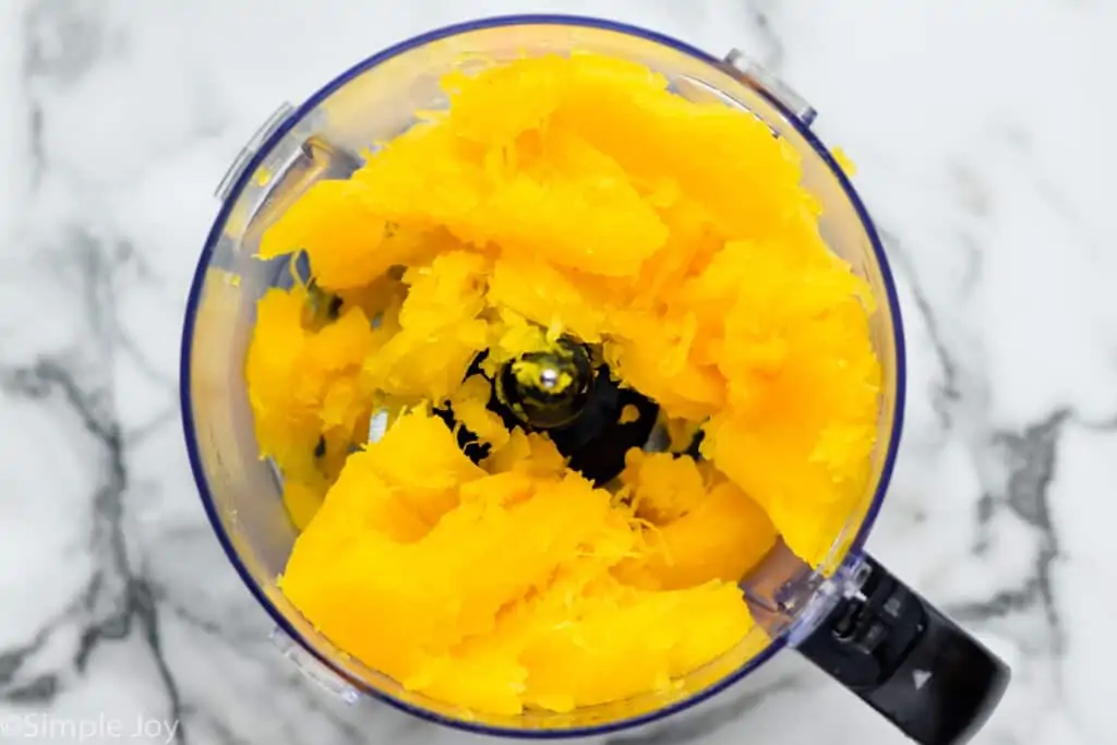 overhead of cooked pumpkin in a food processor before being pureed