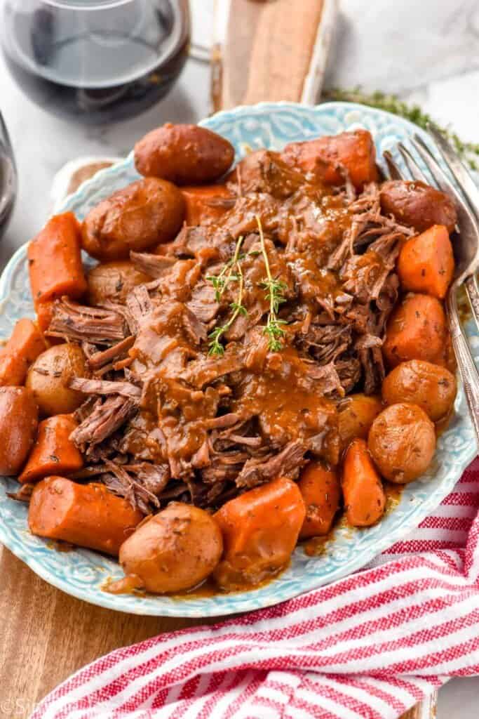 side view of an oven pot roast recipe on a platter with vegetables