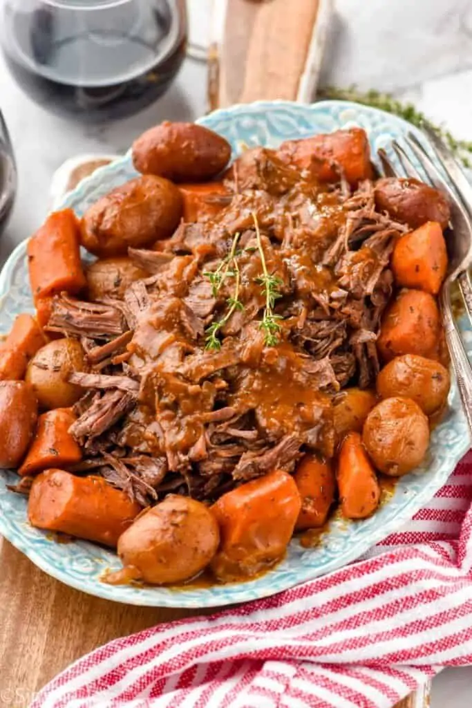 side view of an oven pot roast recipe on a platter with vegetables