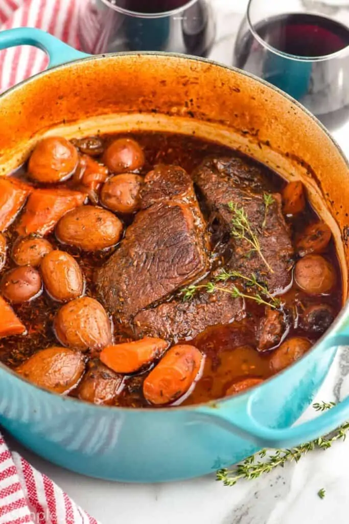 side view of a pot roast in a dutch oven with vegetables that was cooked in the oven