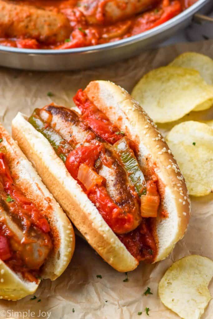 an italian sausage on a bun with sauce and bell peppers
