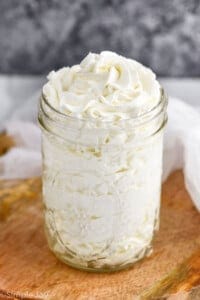 mason jar full of stabilized whipped cream frosting that has been pipped into it