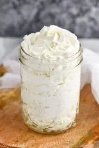 mason jar full of stabilized whipped cream frosting that has been pipped into it