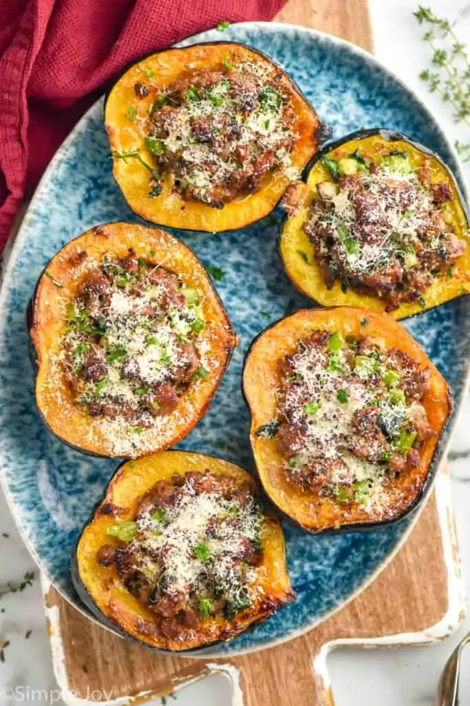 overhead of a platter of acorn squash that have been stuffed with a sausage mixture and baked