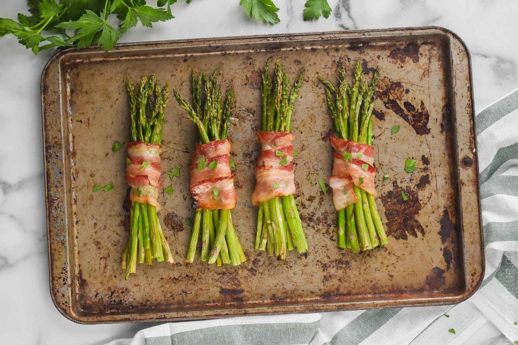 asparagus wrapped in bacon on a baking sheet, fresh from the oven