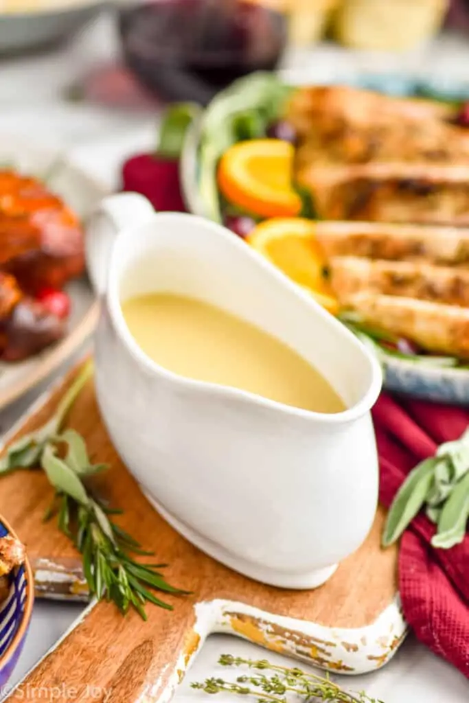 gravy recipe in a turkey boat sitting in front of a platter of turkey