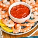 pinterest graphic of small white bowl with shrimp cocktail sauce on a platter with shrimp