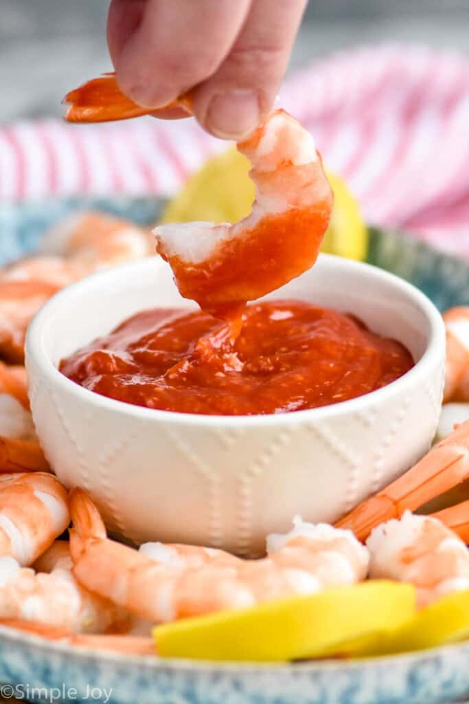 close up of shrimp being dipped into cocktail sauce recipe