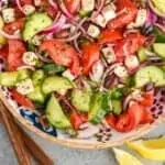 Pinterest graphic overhead view of Mediterranean salad in a bowl in a wooden bowl